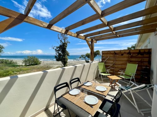 Terrazza fronte mare della Résidence Marina di Bravone con zona pranzo, pergolato e vista oceano a Linguizzetta