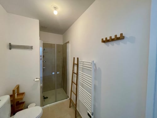 Bagno moderno presso la Résidence Marina di Bravone a Linguizzetta con box doccia, portasciugamani bianco e mobile in legno