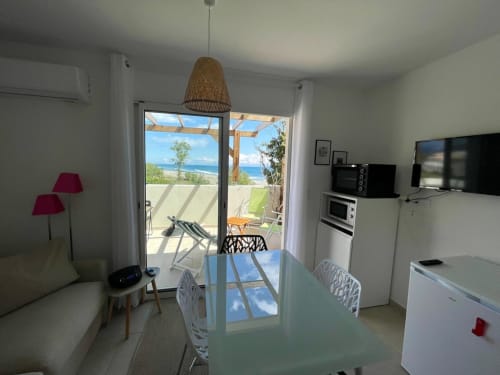 Luminoso appartamento fronte mare a Marina di Bravone con vista sul mare, cucina moderna, zona living e accesso diretto alla spiaggia