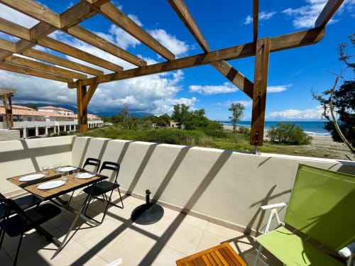 Terrazza di appartamento fronte mare a Marina di Bravone con tavolo da pranzo, pergolato e vista spiaggia a Linguizzetta