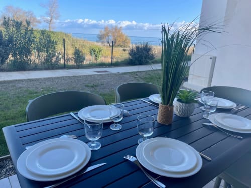Ensemble de table à manger en plein air à la Résidence Marina di Bravone à Linguizzetta avec vue sur la mer, Corse