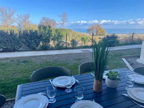 Table de repas en plein air à Marina di Bravone, Linguizzetta, avec vue sur la plage et végétation méditerranéenne