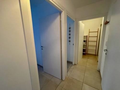 Couloir de l'appartement T3 à Marina di Bravone, Linguizzetta avec portes blanches et carrelage