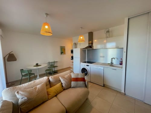 Appartement T3 moderne à la Résidence Marina di Bravone à Linguizzetta avec séjour ouvert, cuisine et canapé crème