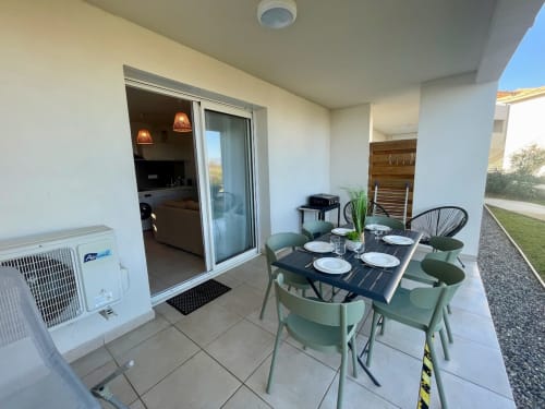 Terrasse meublée de l'appartement Marina di Bravone avec table à manger, chaises et accès à la vue mer à Linguizzetta