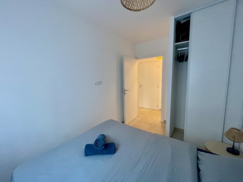 Chambre moderne à la résidence Marina di Bravone, Linguizzetta avec lit, armoire et accès à la salle de bain attenante