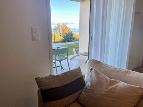 Canapé beige avec vue sur mer depuis l'appartement Marina di Bravone, Linguizzetta, Corse