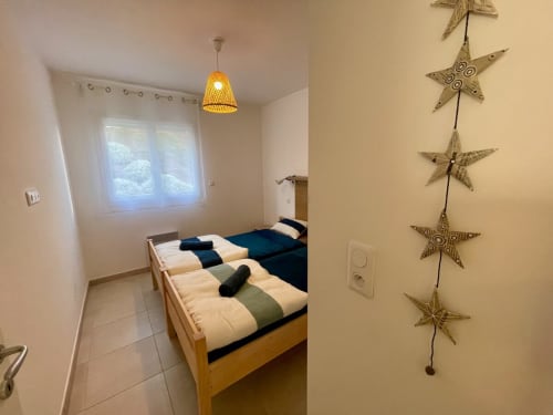 Chambre douillette à l'hôtel Marina di Bravone en Corse avec lits jumeaux, suspension et étoiles décoratives