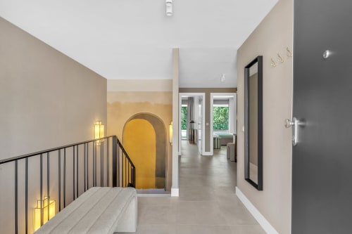 Nowoczesny korytarz w apartamentach HomyMarbella w Elvirii, żółta architektura, schody i widok na ogród