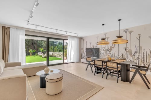 Nowoczesny salon z otwartą przestrzenią i jadalnią w cottage HomyMarbella w Elvirii z widokami na ogród przez drzwi przesuwne