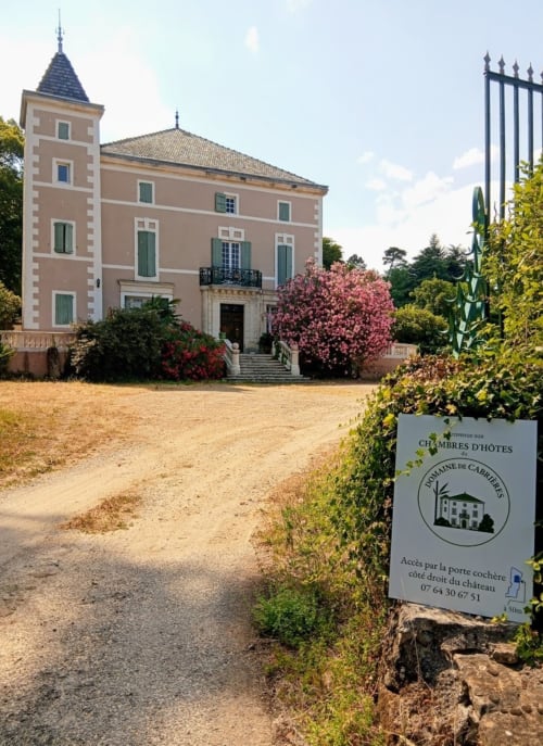 Domaine de Cabrières B&B entrance with pink mansion and flowering trees in St Jean Du Gard