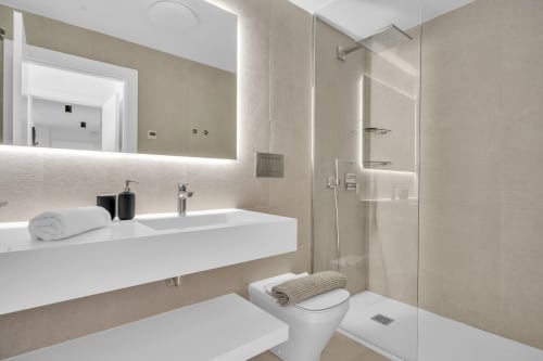 Nowoczesna łazienka w apartamencie SeaView Relaxing Home w HomyMarbella, Elviria z białą umywalką, toaletą i kabiną prysznicową