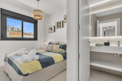 Nowoczesna sypialnia w apartamencie SeaView Relaxing Home, Elviria Marbella, z kolorową pościelą i łazienką en-suite