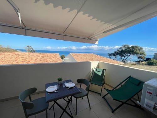 Terrazza dello studio a Résidence Marina di Bravone, Linguizzetta, con tavolo da pranzo, lettini e vista sul mare sulla Corsica