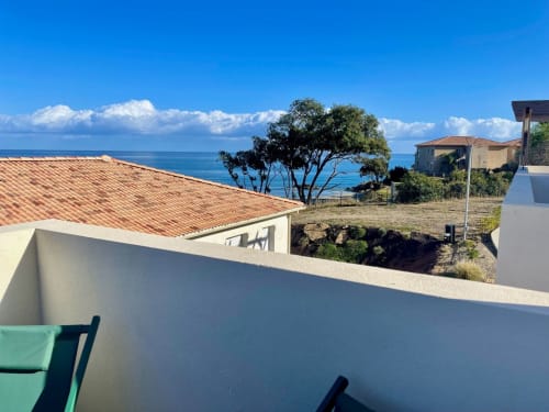 Balcone con vista mare di un monolocale a Marina di Bravone, Linguizzetta, affacciato sul Mediterraneo con muri bianchi e tetti in cotto