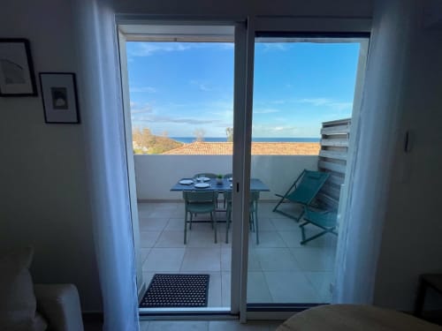 Vista dal balcone della Résidence Marina di Bravone con tavolo da pranzo, lettini e panorama sul mare a Linguizzetta,