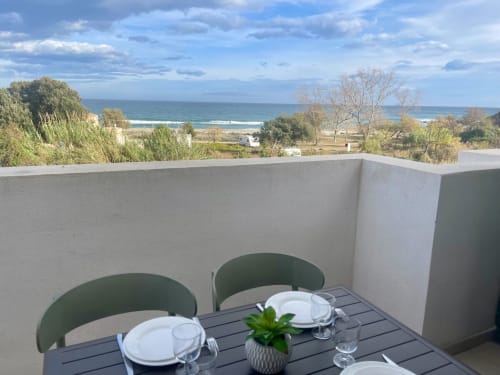Espace de restauration en bord de mer à la Résidence Marina di Bravone avec vue sur l'océan et la côte