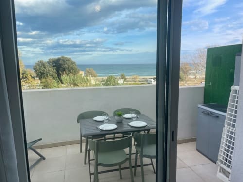 Terrasse balcon de la Résidence Marina di Bravone avec vue mer, table à manger et accès à la plage à Linguizzetta