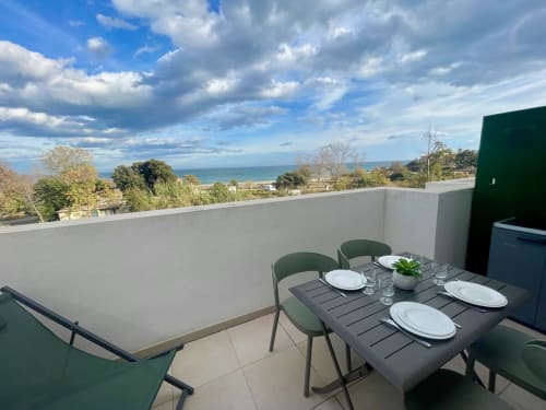 Terrasse sur le toit de la Résidence Marina di Bravone avec espace repas donnant sur la plage et la mer de Corse