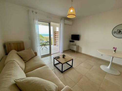 Monolocale con vista mare presso Résidence Marina di Bravone, arredamento beige e balcone fronte oceano a Linguizzetta