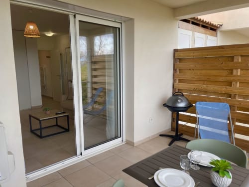 Patio di monolocale a Marina di Bravone, Linguizzetta con tavolo da pranzo, testata in legno e porte scorrevoli in vetro