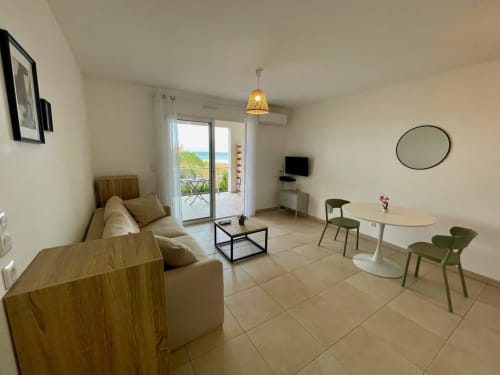 Monolocale presso Résidence Marina di Bravone con vista mare, divano beige, tavolo da pranzo e terrazza con vista sul