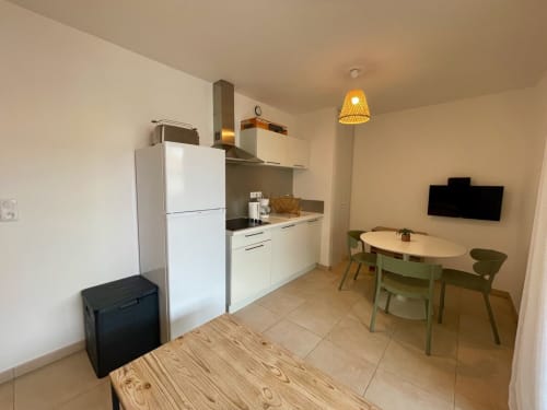 Cuisine et salle à manger modernes de la Résidence Marina di Bravone, Linguizzetta avec électroménagers blancs et table en bois