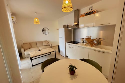 Appartement moderne à la Résidence Marina di Bravone avec cuisine ouverte, salle à manger et séjour aux tons beige
