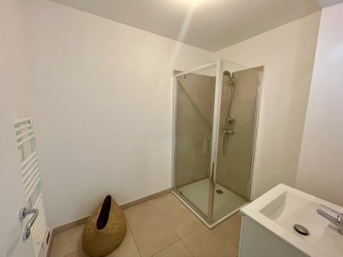 Salle de bain moderne avec douche, lavabo blanc et porte-serviettes à la Résidence Marina di Bravone, Linguizzetta