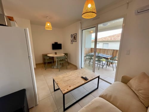 Séjour contemporain à la Résidence Marina di Bravone avec terrasse, coin repas et espace détente