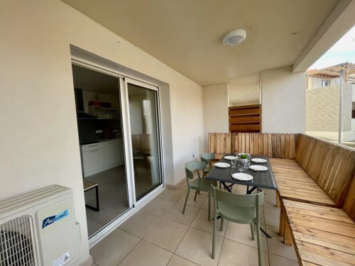 Zone de repas en front de mer à la Résidence Marina di Bravone avec table, chaises et accès à la cuisine