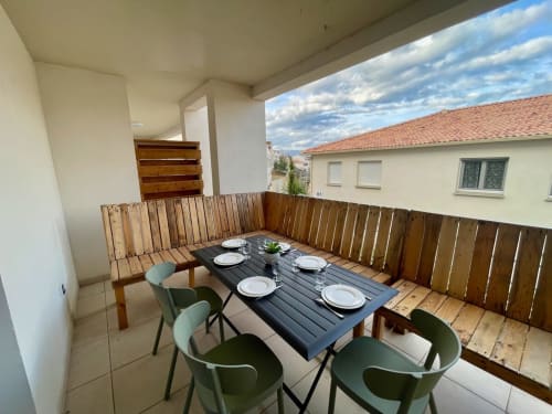 Balcon de l'appartement Marina di Bravone avec table à manger, chaises, balustrade en bois et vue sur mer à Linguizzetta