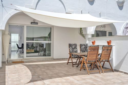 Soleada terraza de la casa HomyMarbella en Elviria con zona de comedor, tumbonas y modernas puertas de patio
