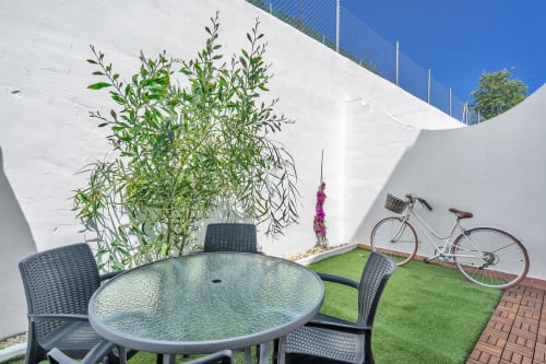 Zona de terraza en la casa HomyMarbella de Marbella con mesa, sillas, maceta y bicicleta