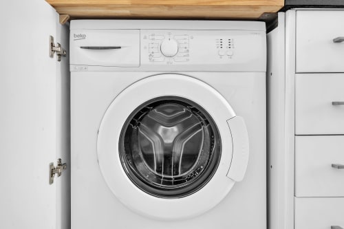 Lavadora Beko blanca integrada en la cocina de la casita HomyMarbella en Elviria, Marbella