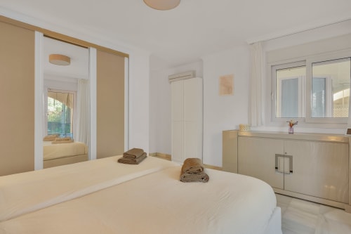 Modern bedroom at Casa Perla Marbella in Elviria with garden view, bed, vanity, and bright natural light