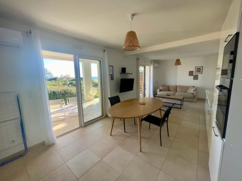 Spacious beach apartment at Résidence Marina di Bravone featuring dining area, living room, and sea views from terrace