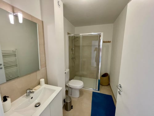 Modern bathroom with sink, toilet, and glass shower enclosure at Résidence Marina di Bravone, Linguizzetta