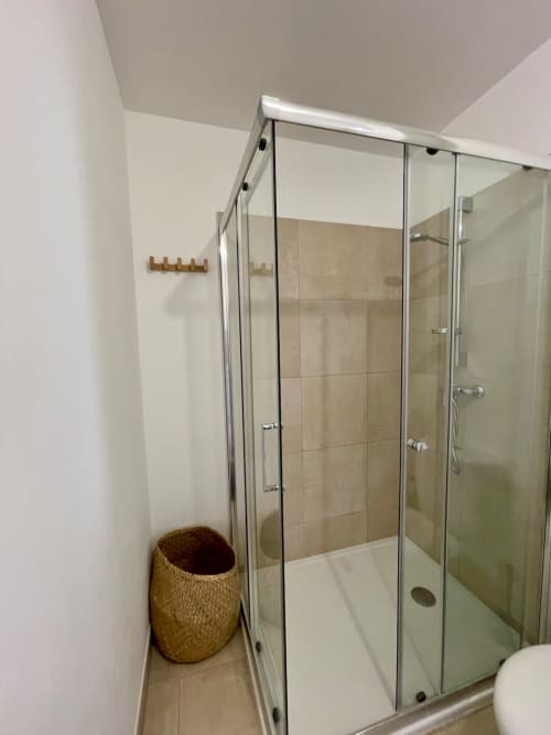 Modern glass shower enclosure in beachfront apartment bathroom at Résidence Marina di Bravone, Linguizzetta