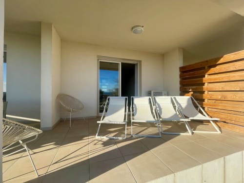 Modern terrace at Résidence Marina di Bravone with loungers, wooden screen, and sea views in Linguizzetta