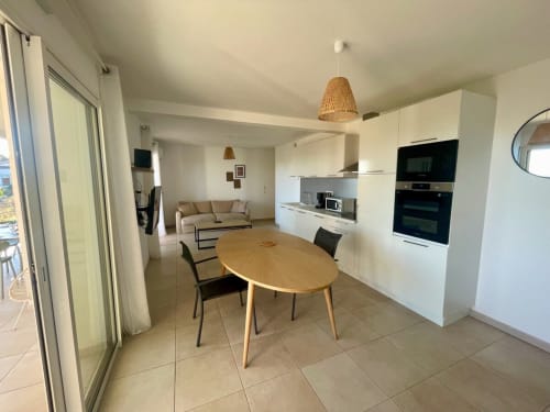 Bright open-plan apartment at Résidence Marina di Bravone with dining table, kitchen, sofa, and beach access in Linguizzetta