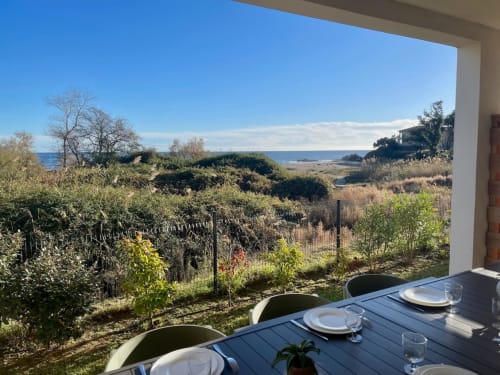 Coastal terrace dining at Marina di Bravone with sea view, garden, and Corsican landscape