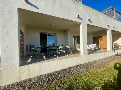 Marina di Bravone beachfront apartment patio with dining area and lounge chairs in Linguizzetta