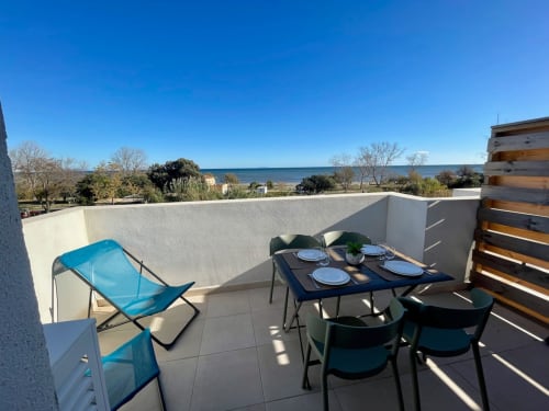 Terrazza di Marina di Bravone con vista mare, tavolo da pranzo, lettino blu e accesso alla spiaggia a Linguizzetta