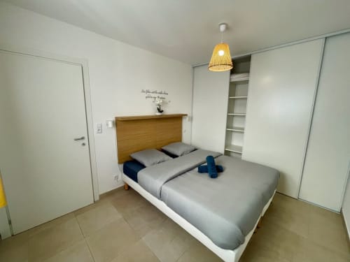 Camera moderna presso Résidence Marina di Bravone, Linguizzetta, con letto matrimoniale, testata in legno e vani contenitori.