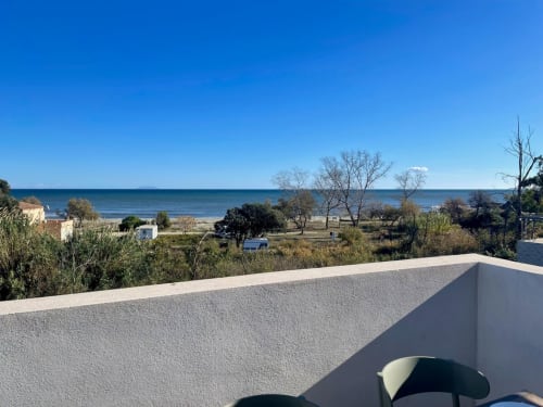 Vista panoramica sul mare dal balcone di Marina di Bravone che si affaccia sulla spiaggia, la costa mediterranea e i giardini paesaggistici