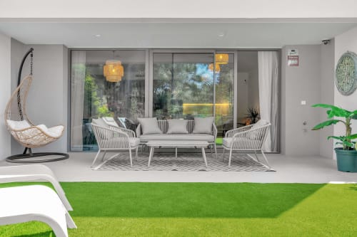 Nowoczesny taras ogrodowy z meblami wypoczynkowymi i zagospodarowaniem krajobrazu w HomyMarbella Townhouse Eden Golf Chaparral w Elvirii