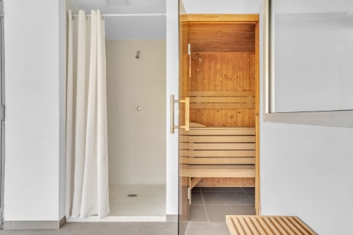 Nowoczesna łazienka z drewnianą sauną i kabiną prysznicową w apartamencie HomyMarbella w Elvirii
