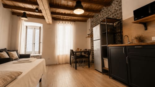 Modernes Studioapartment im Zentrum von Bergamo mit Bett, Kochnische, Essbereich und Holzbalkendecke