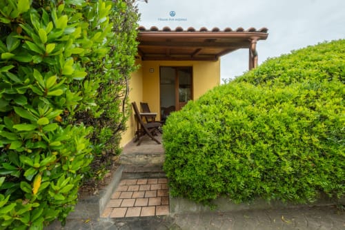 Ingresso giardino Locandiere Suite presso House Live Express, Quartu Sant'Elena, con siepi rigogliose e patio in cotto